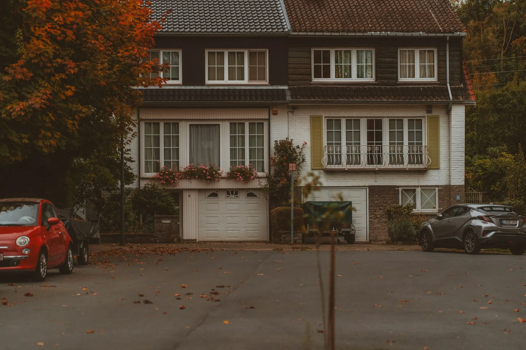 Zwei Autos vor der Einfahrt eines Hauses